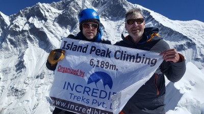 At Island Peak summit with a banner